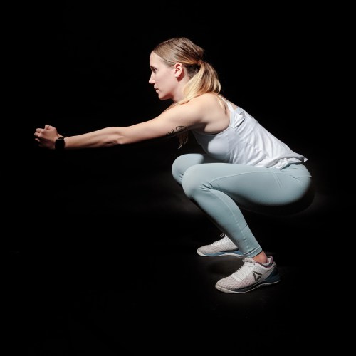 side-view-photo-of-woman-doing-squats-against-black-2417485