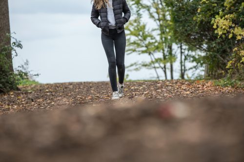 woman-in-black-leggings-while-walking-on-brown-road-663437